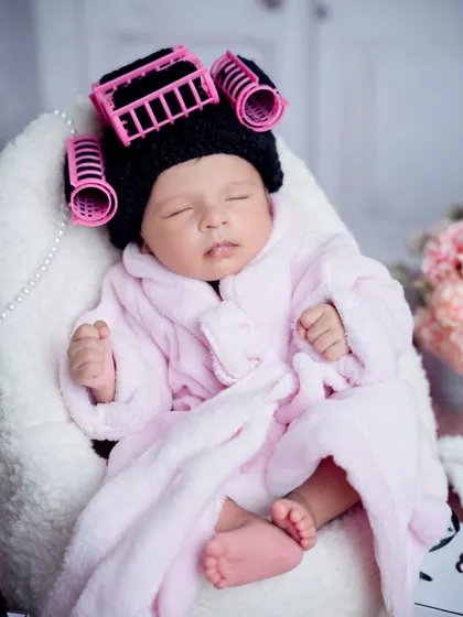 A close-up on our spa baby, showing off her adorable knitted rollers and fluffy pink robe. She is sleeping so peacefully.