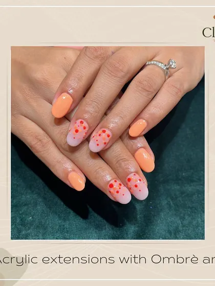 Adding a bit of polka-dot fun. These acrylic extensions feature a peach-colored ombré effect with playful red polka dots for a cheerful and unique manicure.