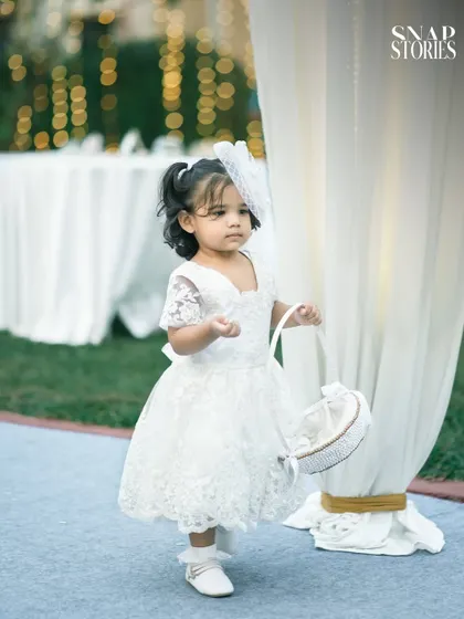 An adorable flower girl in her white lace dress, ready for her walk down the aisle. We capture all the charming details and participants of your wedding day.