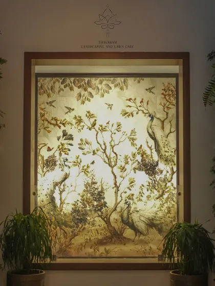 This backlit mural depicts a classic scene of peacocks and birds in a forest, framed like a window. It serves as a beautiful piece of art that brings nature indoors.