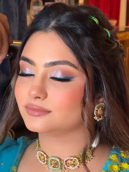A close-up on the shimmery, graded eyeshadow with a sleek feline liner in blue. This artistic choice makes the Haldi look unique and memorable.