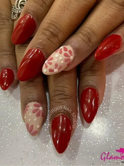 A classic combination of red and nude. We paired glossy red nails with accent nails featuring a delicate, hand-painted floral pattern in shades of red and pink on a nude base.