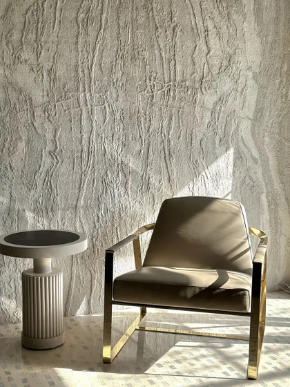 The full frontal view of the lounge chair and its accompanying side table. The composition emphasizes symmetry and balance, with the textured wall providing a subtle, organic backdrop to the clean lines of the furniture.
