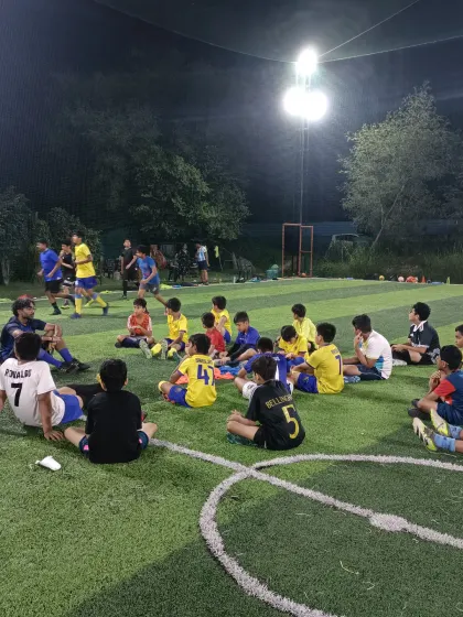 The game isn't just won with your feet, but with your mind. Here, our AIFF licensed coach breaks down tactics with the team under the lights, turning players into thinkers.
