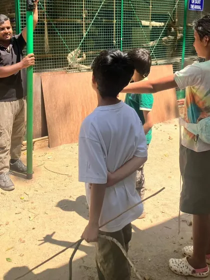 Children listen intently during a demonstration on how to use rescue equipment, learning about the practical tools used by ornithologists and wildlife rescuers.