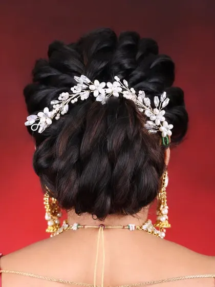 We also teach intricate bridal hairstyling. This elegant braided bun with a floral accessory is one of the many styles you will master.
