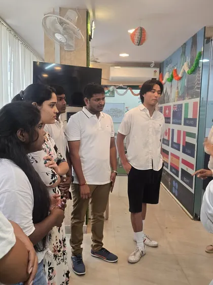 Our students interacting during a group activity. You can see our wall of flags in the background, representing the many languages and cultures present at our academy.