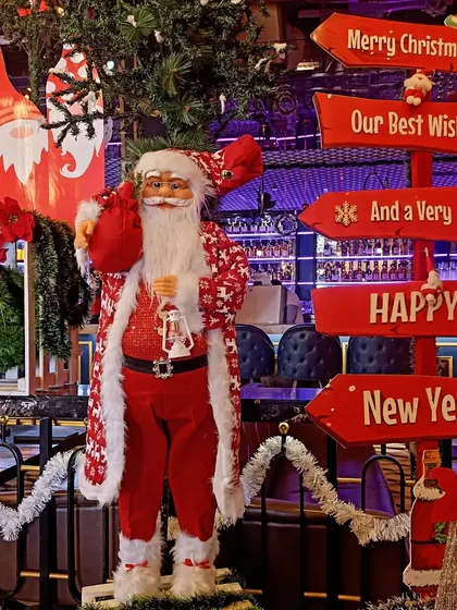 A classic Christmas setup for a restaurant. The decor features a life sized Santa Claus, festive signage, and traditional red and white decorations to create a warm and welcoming holiday atmosphere.
