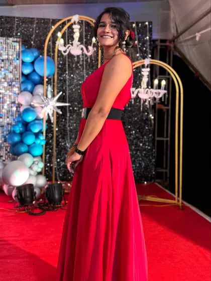 Looking elegant in a red gown for a special birthday celebration. The decor with blue and silver balloons created a festive and celebratory mood.