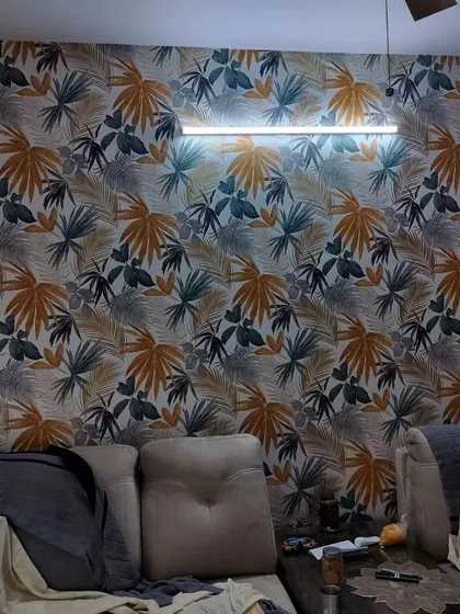 A living room with a vibrant tropical leaf wallpaper. The mix of colors makes the room feel lively and energetic.