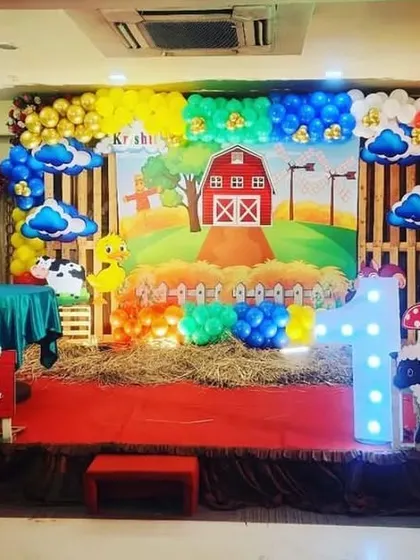 An 'Old MacDonald's Farm' theme, which is a fun and interactive party concept. The stage features a barn backdrop, hay bales, and cutouts of all the favorite farm animals like cows, pigs, and sheep.