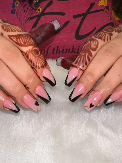 Edgy and elegant. This design features a sharp V-cut French tip in black on coffin-shaped nails, with a tiny heart detail for a subtle surprise. It’s a modern and graphic look that’s perfect for making a statement.