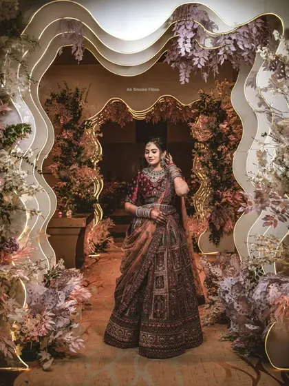 A breathtaking portrait of the bride in her intricate lehenga, framed by the stunning reception decor.