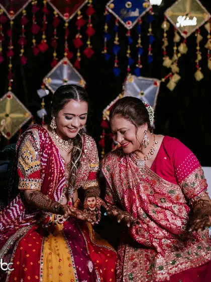 The bride sharing a special moment with her mother, showing her the intricate portrait of her husband-to-be on her hand.