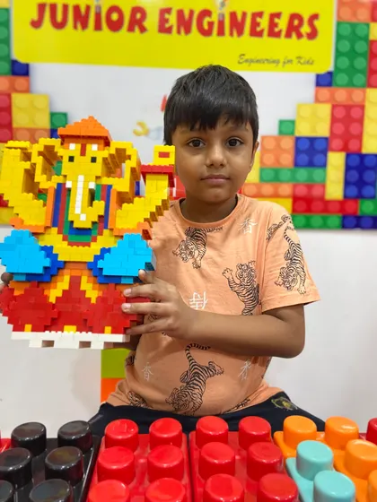A student with his colorful LEGO Ganesha, built using smaller pixel-style bricks, showcasing a different building technique.