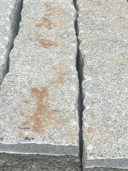 A close-up of natural rough stone pillars, showing the texture and color variations.