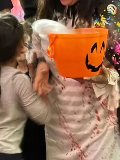 A witch's cauldron bubbling with smoke adds to the magical atmosphere. The kids love gathering around to see what spooky concoction is being brewed.