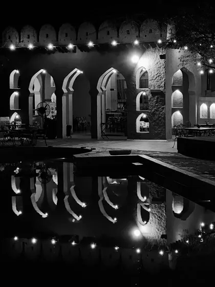 The beautiful architecture of a heritage hotel reflected in the pool at night, where we often do our recovery swims.