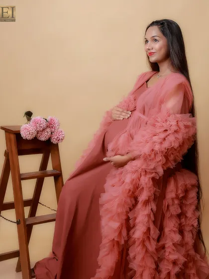 A seated portrait in the dusty rose gown, using a simple wooden stool as a prop to create a classic, elegant look.