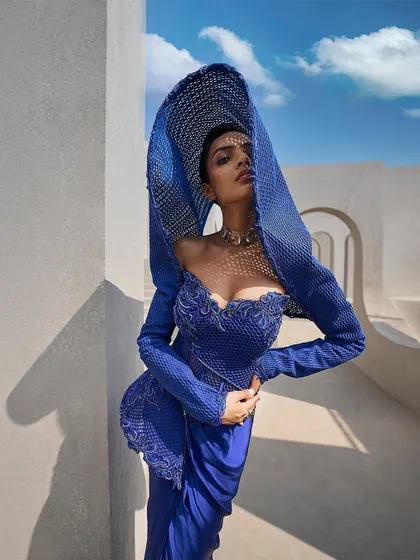 I believe in retelling tradition through structure. Here, an architectural mesh hood in a striking active blue replaces a conventional drape, creating a powerful, contemporary statement for the modern bride.