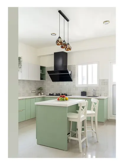 The kitchen, featuring a blend of white and pastel green cabinetry and an island counter that doubles as a breakfast spot for kids. Stained glass pendants add a touch of old-school charm.