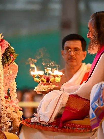 I am holding the sacred lamp during a Navratri puja. These rituals, passed down through millennia, are designed to purify the environment and uplift the consciousness of everyone present.