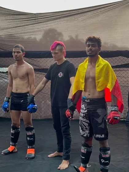 Respect and victory. Our fighter stands with his opponent and the referee, embodying the sportsmanship we value.