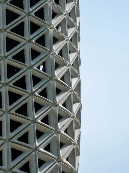 A detailed close-up of VERTO's triangulated facade. The gradient in the openings is a performance-driven feature, with larger apertures at air intake and outlet points. This demonstrates how every aesthetic choice is backed by engineering logic.
