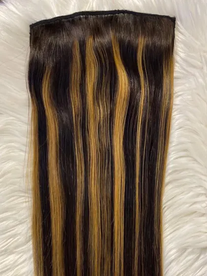 A close-up of our clip-in extensions with bold blonde highlights. The 100% human hair can be styled, curled, or straightened to blend seamlessly with your look.