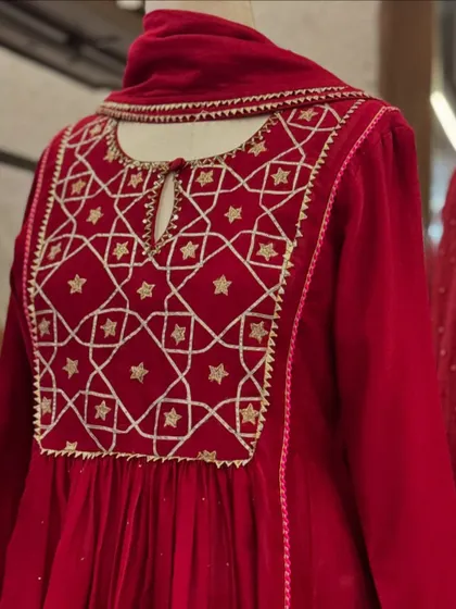 A detailed shot of the geometric and star-patterned embroidery on a red velvet kurta. This blend of traditional motifs with a modern layout is what makes a piece stand out.