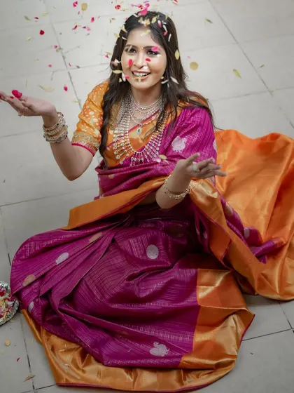 Another joyful shot with the flower petals, capturing the celebratory spirit of wearing a beautiful saree.