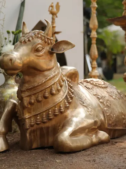 A beautifully crafted golden statue of Nandi, the sacred bull, adorned with a floral garland. This element adds a touch of divine blessing and tradition to the wedding decor.
