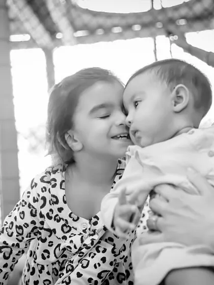 The play zone is a great place for siblings to bond and make sweet memories. This beautiful black and white photo captures a tender moment between two sisters during a birthday celebration.