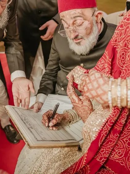 A sacred moment from a Nikah ceremony, as the bride signs the marriage register, witnessed by her elders. We capture these traditions with respect and an eye for detail.