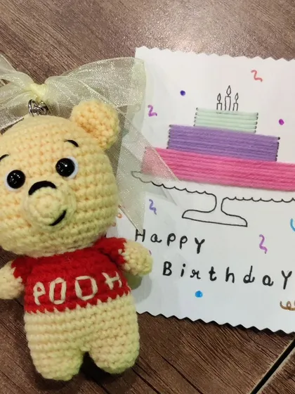 The finished Pooh Bear keychain next to a handmade birthday card.
