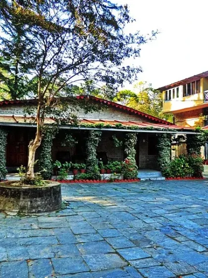 The stone-paved courtyard of the hotel, surrounded by ivy-covered pillars. This space serves as a rustic and charming entry point to different parts of the property.