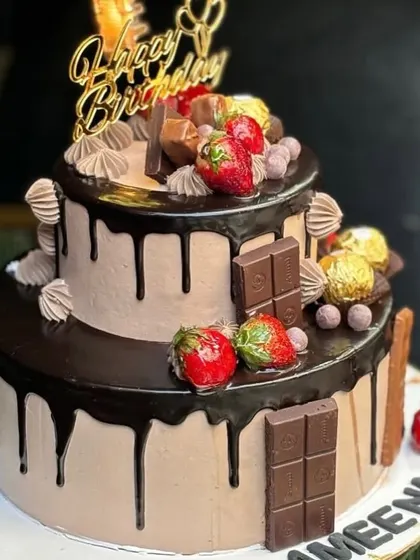 Another view of the decadent two-tier chocolate drip cake, showcasing the generous toppings and rich chocolate frosting. This cake is fully eggless and can be customized with your favorite treats.
