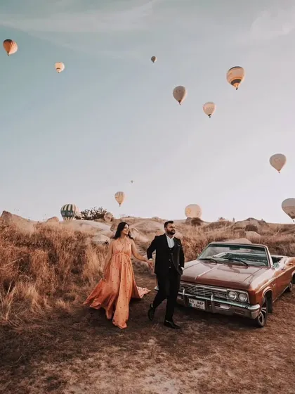 A candid moment of the couple walking hand-in-hand. The gown flows beautifully as they move, adding a touch of elegance to this adventurous shot in Turkey.