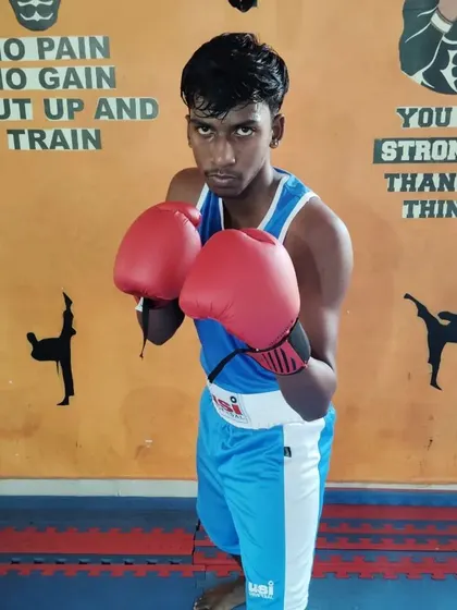 A focused young boxer ready to train. His stance and guard show the fundamental boxing techniques we teach at the academy.
