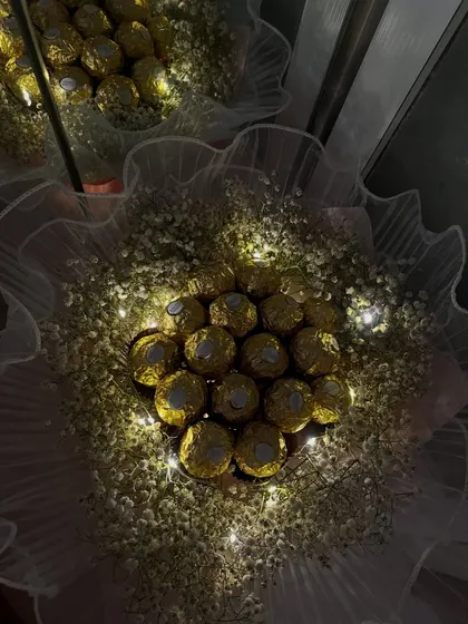 Imagine their face when they see this. I arrange luxurious Ferrero Rocher chocolates in a cloud of baby's breath and weave in delicate fairy lights to create a truly magical and edible gift, perfect for a memorable first date or anniversary.