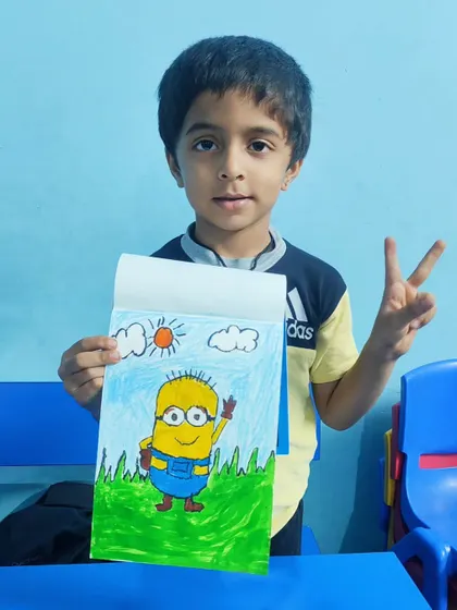 A proud student gives a peace sign as he shows off his awesome Minion drawing.