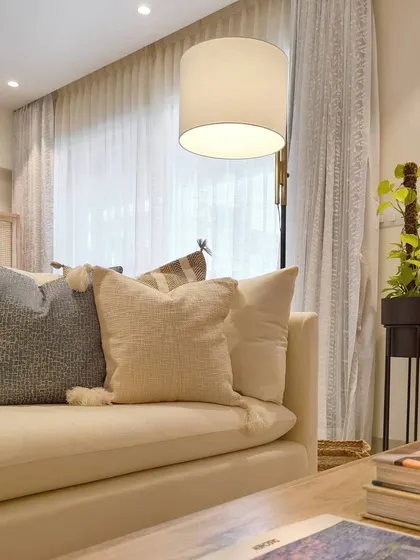 A close-up of the styling in the Breeze Home reading room. Layering pillows with different textures on a neutral sofa is a simple way to add depth and comfort to a space.