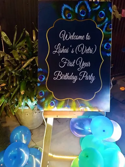 A personalized welcome board for a peacock-themed first birthday party. The design incorporates the rich colors and feather motifs of the theme, setting the tone from the moment guests arrive.