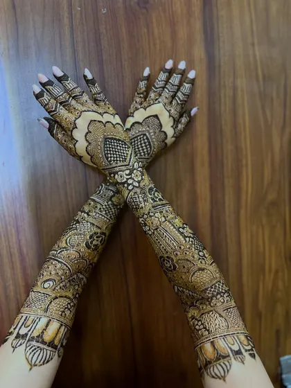 A full view of the bridal henna against a wooden background, which makes the design stand out.