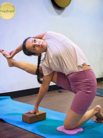 We modify complex poses like Vishvamitrasana to make them accessible. Using a block for hand support and a pad for the knee, this student can safely work on the deep hip opening and twist, building strength and flexibility with proper alignment.