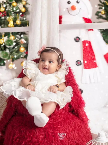 What more could one ask for? This happy baby girl, sitting on a big red teddy bear, is the perfect picture of Christmas joy.