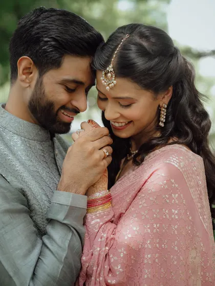 A close-up, romantic portrait of the newly engaged couple, their hands and rings featured prominently, their smiles telling the whole story.