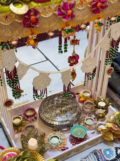 A closer look at a traditional Diwali hamper. This setup features a beautiful silver box, decorated 'diyas', and a stunning 'toran' with pearl and bead work.