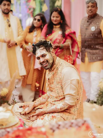 The groom's face is covered in haldi, but his smile says it all. These are the fun, messy, and memorable moments of a wedding.