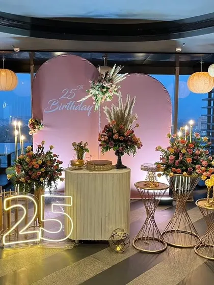 A full view of the elegant 25th birthday setup, showing the balance of floral decor, modern props, and ambient lighting.